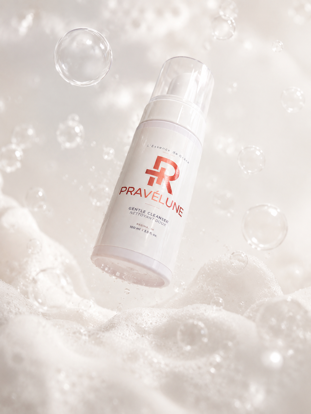 Pravélune™ L'Essence de Grâce Gentle Cleanser hero image featuring the foaming facial cleanser bottle surrounded by soft cleansing foam and bubbles, highlighting a gentle, hydrating cleansing experience for healthier-looking skin.A luxury hero product photograph of Pravélune™ L'Essence de Grâce Gentle Cleanser displayed in rich cleansing foam with floating bubbles, representing a gentle, hydrating facial cleansing ritual suitable for daily use.